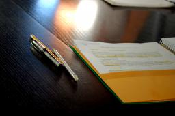 two pens and a folder on a table