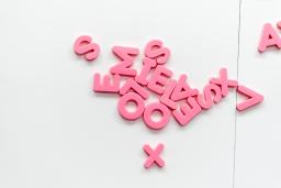 Pink magnetic letters on a white fridge